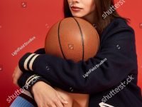 stock-photo-young-woman-showcases-bold-fashion-while-sitting-with-a-basketball-exuding-confidence-and-style-2652149253